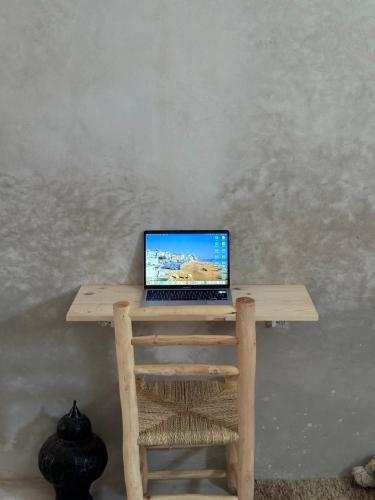 a laptop computer sitting on top of a wooden table at Caban Surf Tamraght in Tamraght Ouzdar