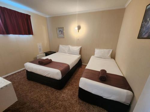 a hotel room with two beds in a room at Mayfair Court Motel in Tokoroa