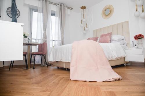ein Schlafzimmer mit einem Bett und einer rosa Decke auf dem Boden in der Unterkunft Paris' Premium Romantic Studio in Paris