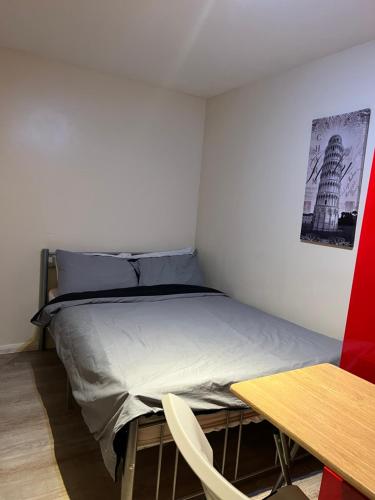 a small bedroom with a bed and a table at Oxborne Rooms UK - Seaton in London