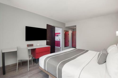 a bedroom with a bed and a desk and a tv at City Express Plus by Marriott Ciudad de México Insurgentes Sur in Mexico City