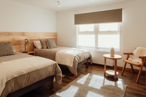 a bedroom with two beds and a window at PURA Hotel in Coihaique
