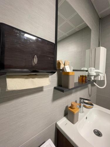 a bathroom with a sink and a mirror at Royal Kate Apartments Spa included 30th floor in Skopje