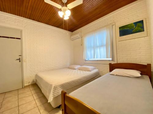 a bedroom with two beds and a ceiling fan at Casa Azul in São Sebastião