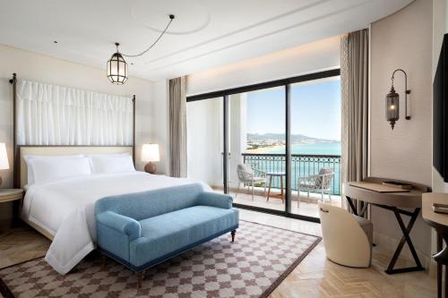 フニデクにあるThe St. Regis La Bahia Blanca Resort - Tamuda Bayのベッドルーム1室(ベッド1台、デスク、大きな窓付)