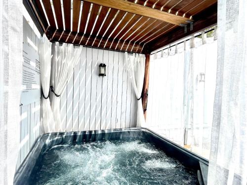 a jacuzzi tub in a room with water at Private Outdoor Spa, Fire Pit - THE RETREAT COOLUM BEACH in Coolum Beach