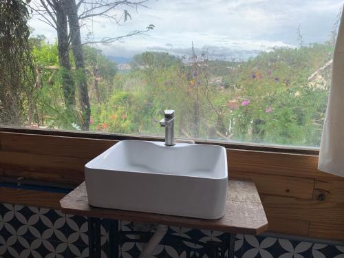 um lavatório branco sobre uma mesa em frente a uma janela em Romantic house on a pine hill Dalat em Xuan An