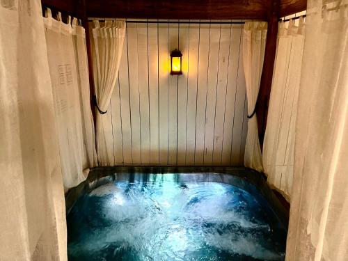 a jacuzzi tub in a room with a light at Private Outdoor Spa, Fire Pit - THE RETREAT COOLUM BEACH in Coolum Beach