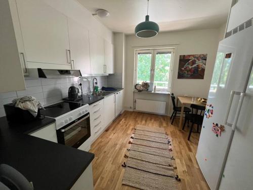 a kitchen with white appliances and a wooden floor at Private room in a shared apartment in Västerås