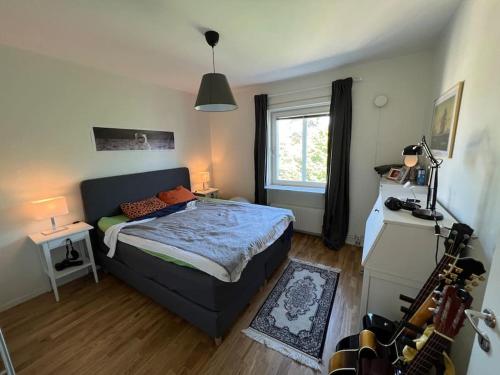 een slaapkamer met een bed en een gitaar erin bij Private room in a shared apartment in Västerås