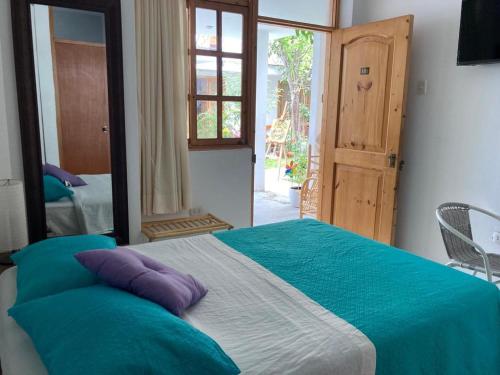 a bedroom with a large bed with blue and white sheets at Garden House Ica in Ica