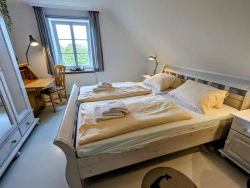 a bedroom with a large bed with a wooden frame at Ferienhaus Ellen, OG Whg in Utersum