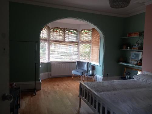 a bedroom with a bed and a window and a chair at Sunny House in Leeds