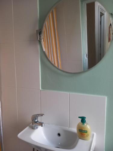 a bathroom with a mirror and a sink at Sunny House in Leeds