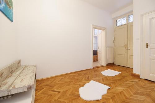 Habitación blanca con suelo de madera y paredes blancas. en Central apartment - private sauna en Viena