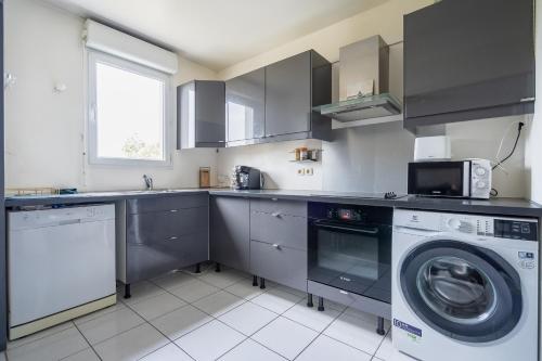 une cuisine avec un lave-linge et un lave-linge dans l'établissement SWEET CONDO - 10 DISNEY - 1 MIN GARE, à Bussy-Saint-Georges