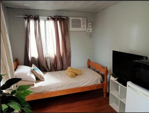 een kleine slaapkamer met een bed en een televisie bij The City Dweller Kingaroy in Kingaroy