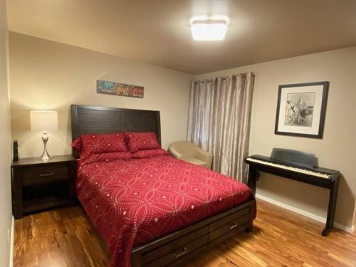 a bedroom with a red bed and a piano at Hidden Gem in SE Boise with hot tub and wood burning fireplace in Boise