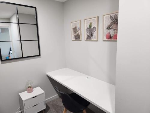 - un bureau blanc dans une chambre avec une chaise noire dans l'établissement Home@Braddon, à Canberra
