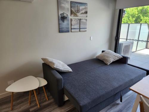 Cette chambre comprend un lit, une chaise et une fenêtre. dans l'établissement Home@Braddon, à Canberra