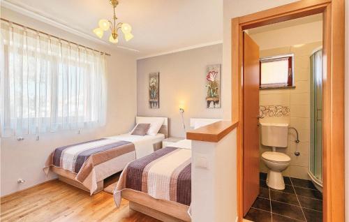 pokój hotelowy z 2 łóżkami i toaletą w obiekcie Beautiful Home In Fazana With Kitchen w Fažanie