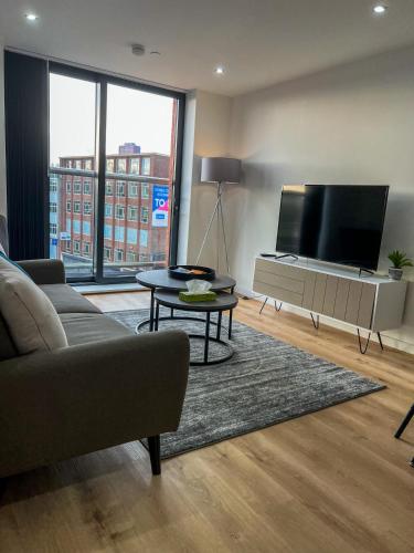 a living room with a couch and a flat screen tv at Elmardi Residence - 2 Bedroom Apartment City Centre in Birmingham