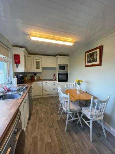 a kitchen with a wooden table and chairs and a table at Sandpit Cottage in Waterford