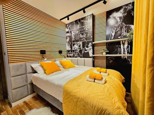 - une chambre avec un grand lit et des oreillers jaunes dans l'établissement Eddie's Luxury Apartments, à Gliwice
