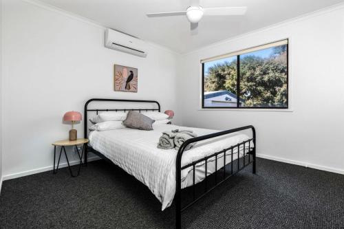 1 dormitorio con cama y ventana en Seabreeze Cottage Cape Paterson, en Cape Paterson