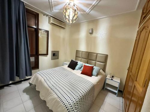 um quarto com uma cama e um lustre em Jawhara Jacobs apartment em Fez