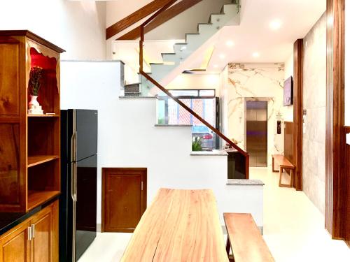 eine Treppe in einem Haus mit einem Holztisch in der Unterkunft The Nam’s House-Nha Trang in Nha Trang