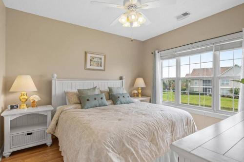 a white bedroom with a bed and a window at 2BR 2BA Waterfront Villa 10min to Beach and Market Common in Myrtle Beach
