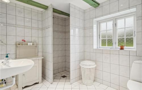 a white bathroom with a sink and a window at 2 Bedroom Awesome Apartment In Faaborg in Fåborg