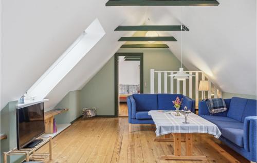 uma sala de estar com sofás azuis e uma televisão em 2 Bedroom Awesome Apartment In Faaborg em Faaborg