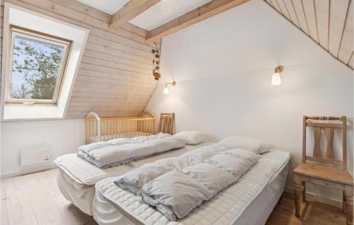 Bredebroにある3 Bedroom Lovely Home In Bredebroの白い壁の客室で、ベッド2台、窓が備わります。