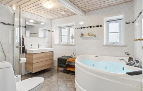 a bathroom with a tub and a toilet and a sink at 3 Bedroom Lovely Home In Bredebro in Bredebro