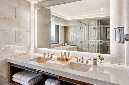 a bathroom with two sinks and a large mirror at JW Marriott, Anaheim Resort in Anaheim