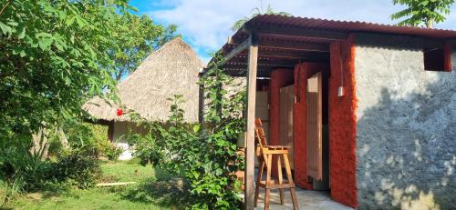 otwarte drzwi domu z krzesłem na zewnątrz w obiekcie Hostal Zirumake Dentro del Parque Tayrona w mieście El Zaino