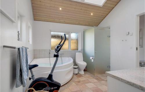 a bathroom with a white tub and a toilet at Stunning Home In Esbjerg V With Kitchen in Esbjerg