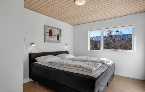 a bedroom with a black bed with a window at Stunning Home In Esbjerg V With Kitchen in Esbjerg