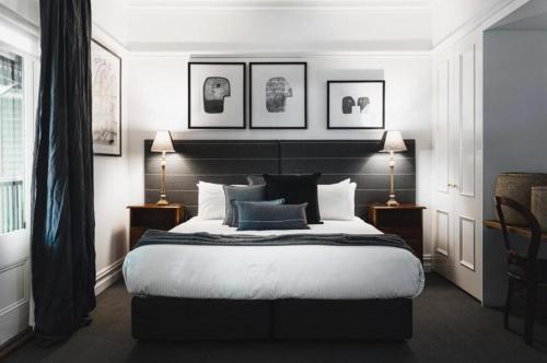 a bedroom with a large bed and two lamps at Hotel Bellinzona Daylesford in Hepburn Springs