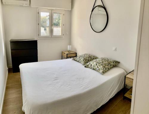 une chambre avec un lit blanc et un miroir dans l'établissement Appartement 3 étoiles Plage & Commerces Saint-Aygulf, à Saint-Aygulf