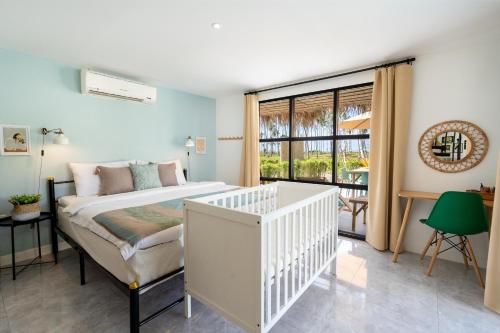 sypialnia z białym łóżeczkiem dziecięcym w pokoju w obiekcie Manao Seaview Pool Villa 25 - 5 Mins Walk To The Beach w mieście Ko Lanta