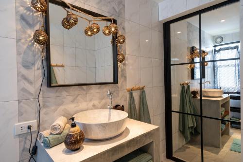 W łazience znajduje się umywalka i lustro. w obiekcie Manao Seaview Pool Villa 25 - 5 Mins Walk To The Beach w mieście Ko Lanta