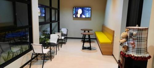 una sala de espera con sillas, una mesa y un osito de peluche en Phoenix Guest House, en Surabaya
