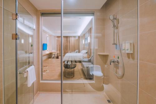 baño con ducha de cristal con un grupo de mesas en Vienna International Hotel (Lianjiang Avenue Xinyuan International Plaza), en Lianjiang