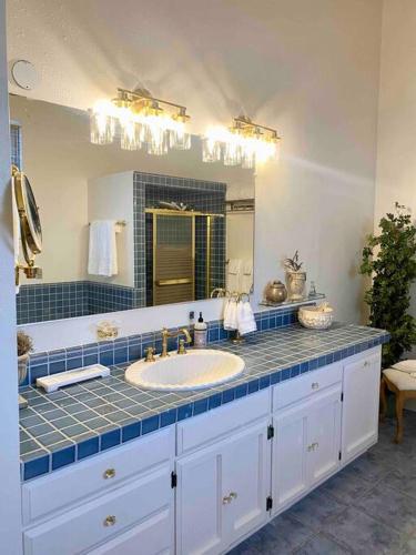 a bathroom with a sink and a large mirror at The Shopkeeper's Cottage ~ CHIC! in Amador City