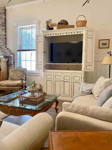 a living room with a tv and a couch and a table at The Shopkeeper's Cottage ~ CHIC! in Amador City