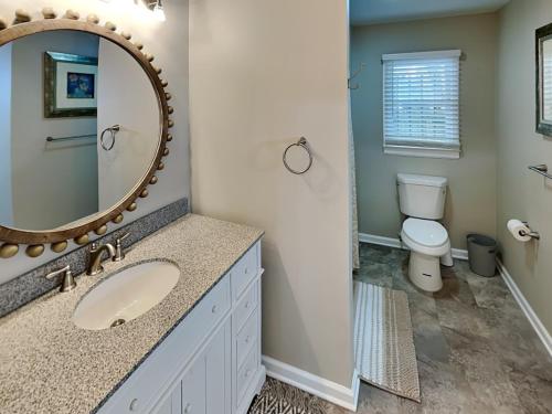 y baño con lavabo, espejo y aseo. en Barnard Row 1404 en Savannah