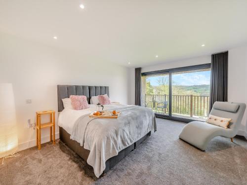 a bedroom with a large bed and a balcony at Westpitt Farm - The Hay Loft in Tiverton